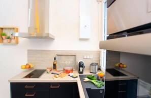 Una cocina moderna con encimera, estufa, fregadero y tostadora.