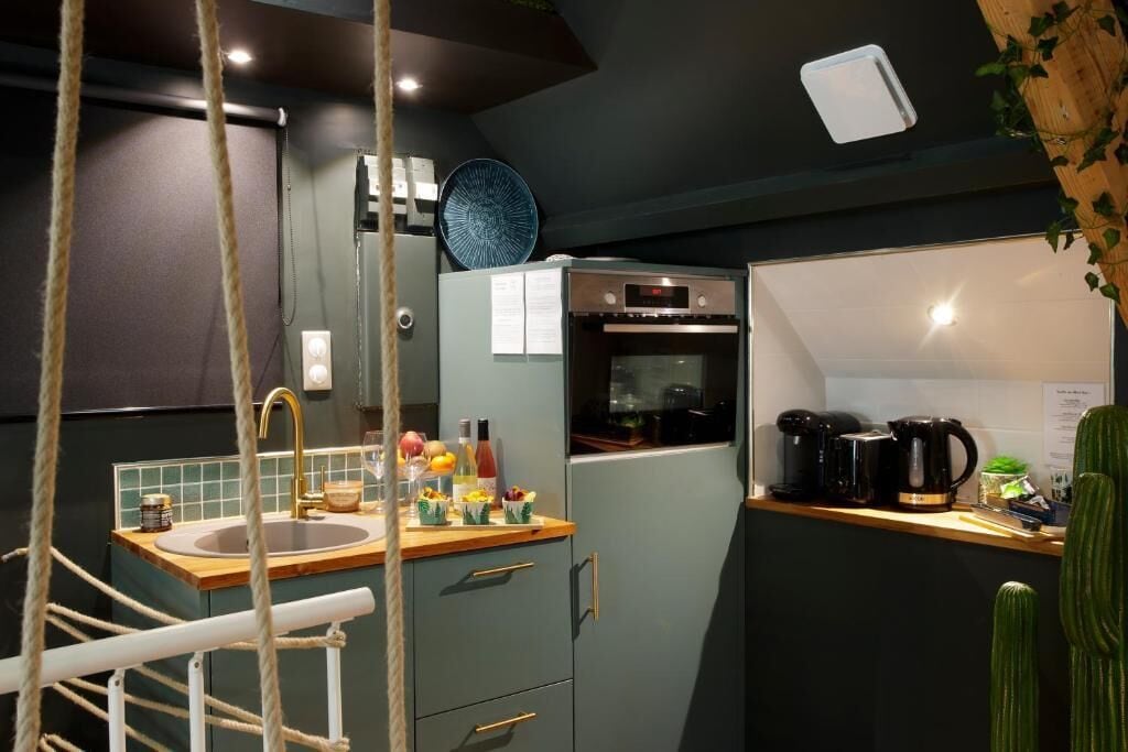 A kitchen with a sink, countertop, refrigerator, oven, and coffee maker.