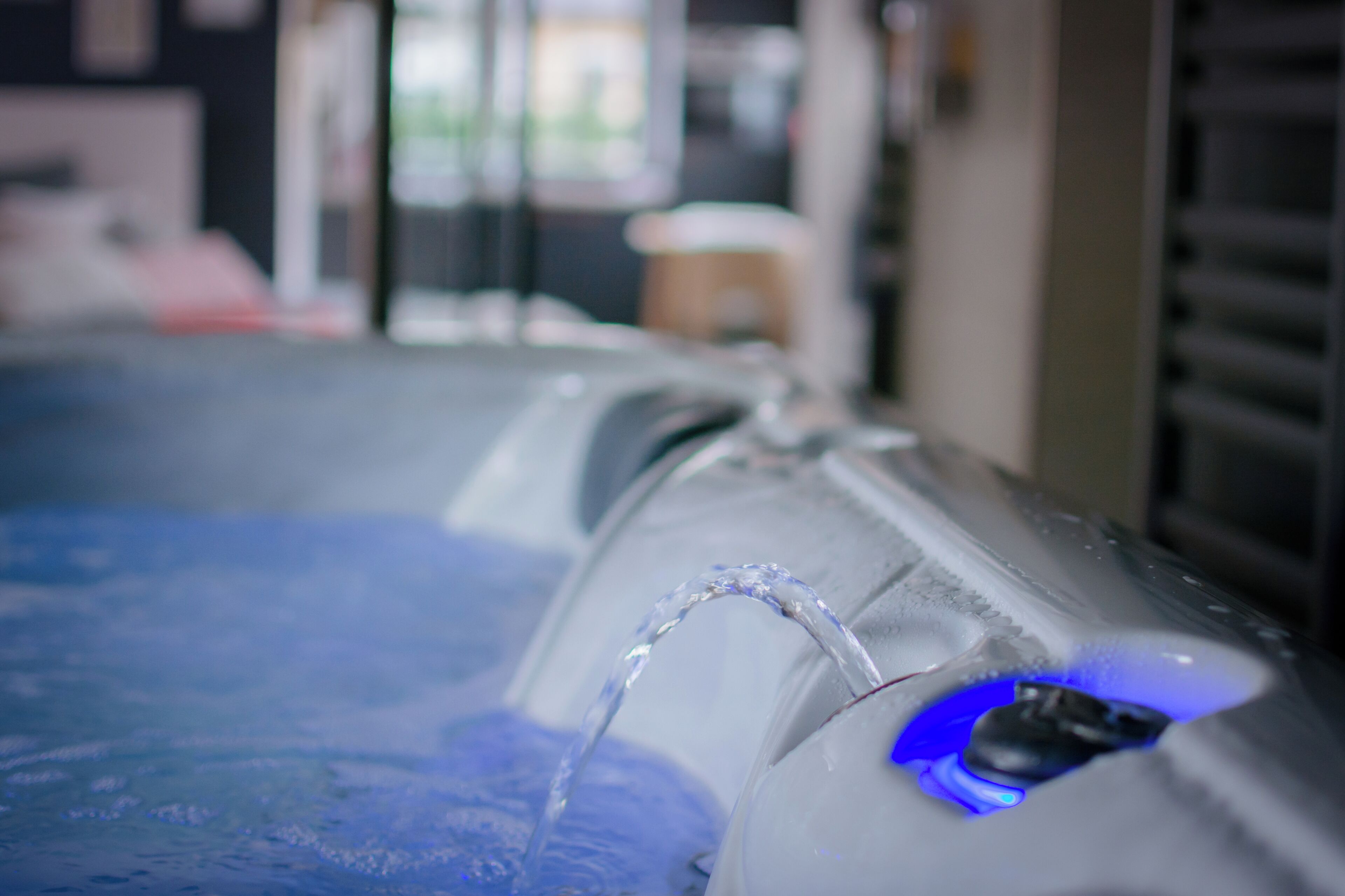 Primer plano de una fuente de agua con luz azul, probablemente parte de un spa o zona de relajación.