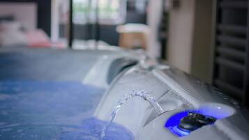 Primer plano de una fuente de agua con luz azul, probablemente parte de un spa o zona de relajación.