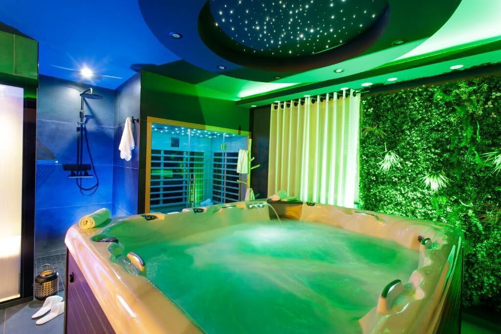 Une salle de bain moderne dotée d’une grande baignoire, d’un espace douche et d’un mur végétal.