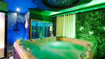 Une salle de bain moderne dotée d’une grande baignoire, d’un espace douche et d’un mur végétal.
