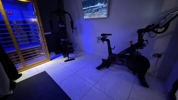 Ett hemmagym med en motionscykel, ett löpband och en styrketräningsmaskin.