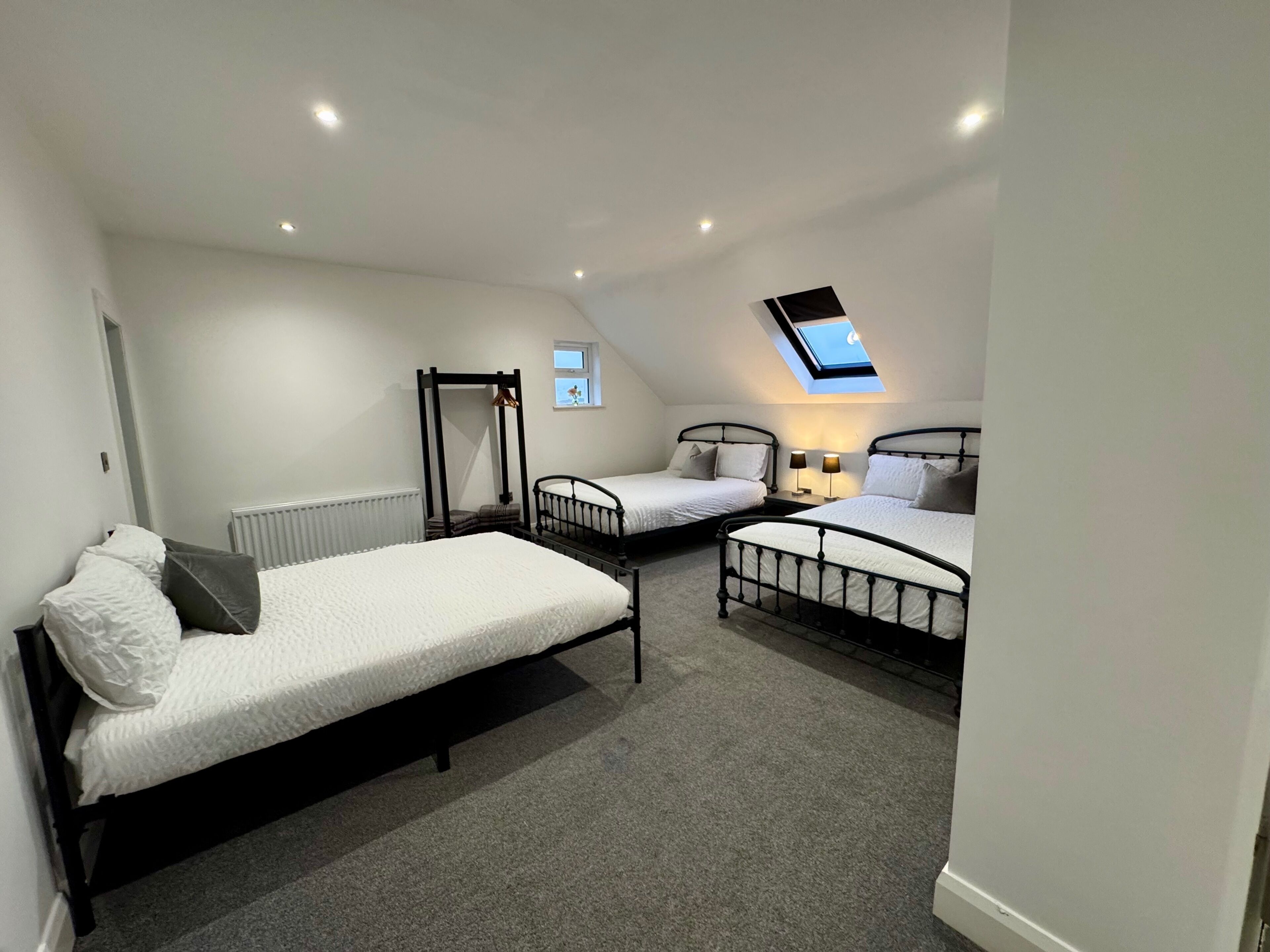 A bedroom with two single beds, a skylight, and a radiator.