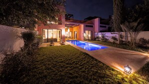 A modern house with a swimming pool, large windows, and a well-lit outdoor area. - Riad Jasmin – Al Maaden Golf – Marrakech (Marrakech)