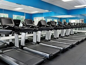 A row of treadmills in a gym with blue walls and large windows. - 1 Bedroom Villa at Marriott Canyon Resort (Phoenix)