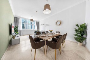 A modern dining room with a large table set for six, surrounded by six chairs with gold legs. - StayShort - Elegant 4, Bedroom in Dubai Marina that Sleeps 10 (Dubai)