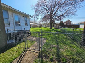 A fenced yard with a grassy area, a tree, and a small shed. - Serene 2-bedroom house in adorable Malvern (Malvern)
