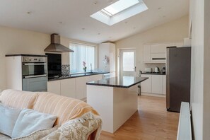 A modern kitchen with a central island, built-in oven, and a skylight. - Spacious Garden Home | Near York | Dog Friendly (York)