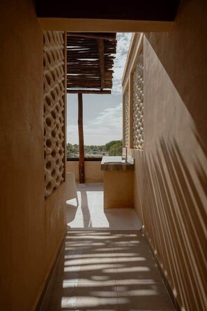 A narrow corridor with a view to an outdoor area, a sink, and a patterned wall. - Boutique studio steps from the sea • Rooftop • Pool (Sisal)