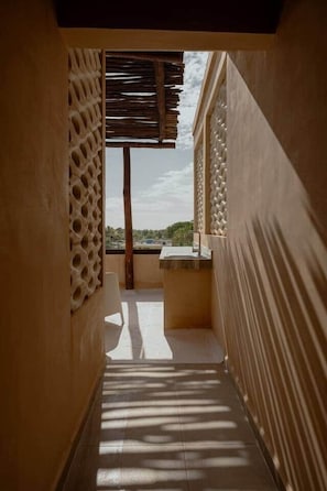 A narrow corridor with a view to an outdoor area, a sink, and a patterned wall. - Boutique Apartment with Ocean View • Rooftop with Pool (Sisal)