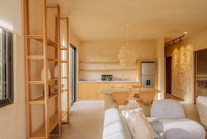 Uma cozinha moderna com área de jantar, prateleiras de madeira e design minimalista.
