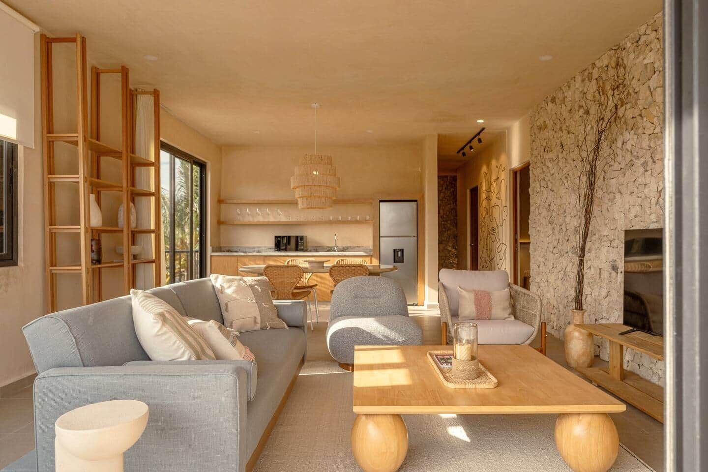 A modern living room with a sofa, coffee table, and a fireplace.