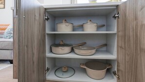 A kitchen cabinet with three shelves, each holding a pot. - Stockyards + Downtown | Bright 1BR | Sleeps 3 - Apartment (Fort Worth)