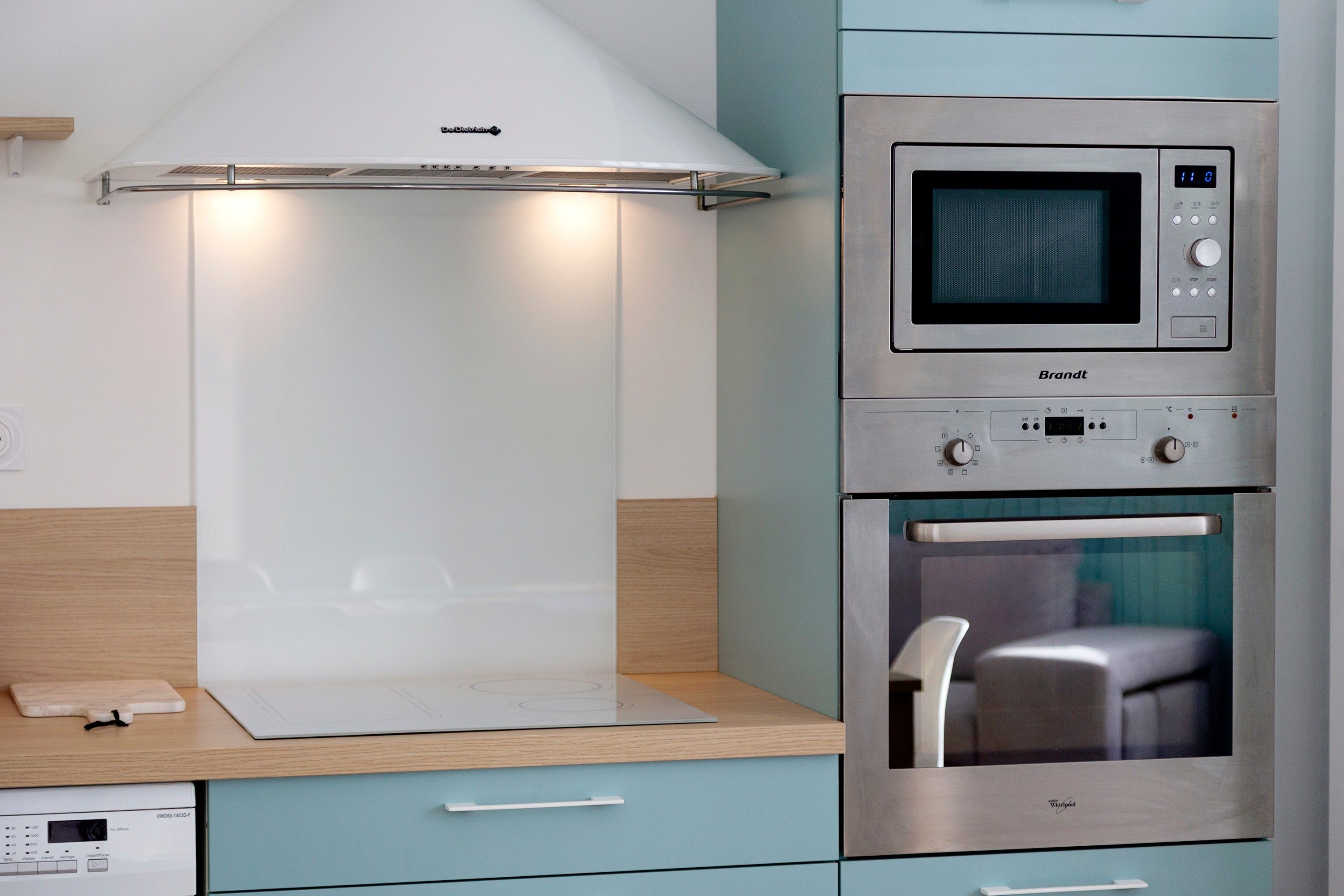 A kitchen with a built-in microwave, oven, and a range hood above the stove.