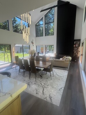 Ein modernes Interieur mit Essbereich, Sofa und großem Fenster.