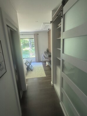 A hallway with a sliding door, a dining area with a table and chairs, and a view of greenery outside. - Experience elevated living in a magnificent brand new modern home set on 5 acres (Clinton Corners)