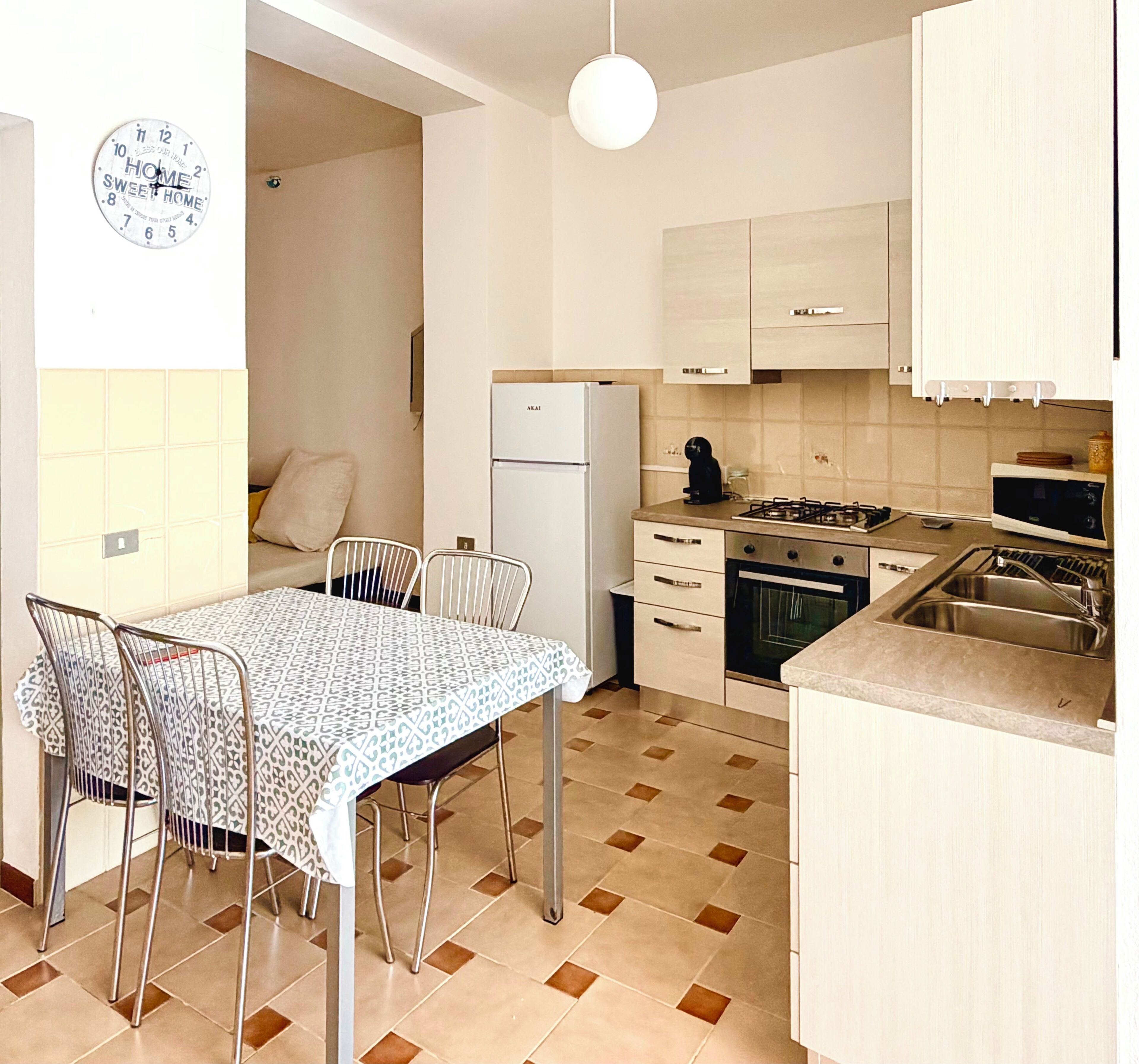 Una cocina compacta equipada con refrigerador, estufa, microondas y lavaplatos.
