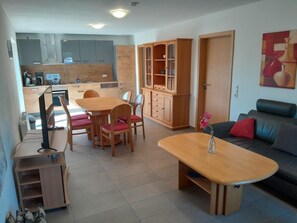 Eine moderne Küche mit Essbereich, einer Couch und einem Schrank.