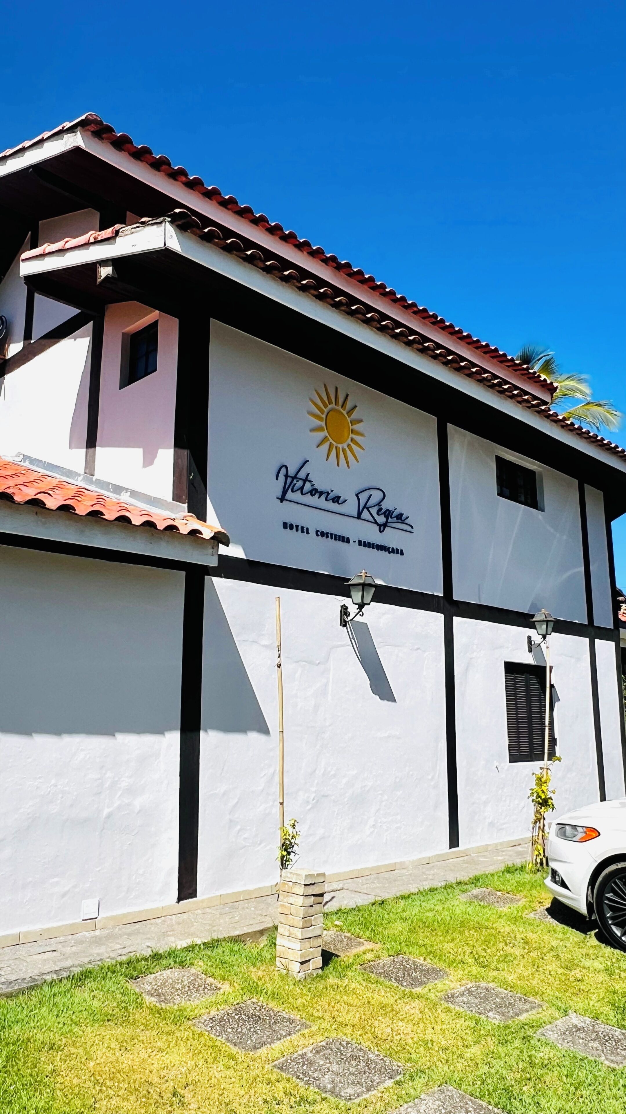 A building with a sign for 'Vitoria Regia Hotel Costeira - Domedouro.'