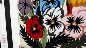 Una mesa de buffet con diversos alimentos y un tapiz floral en la pared.