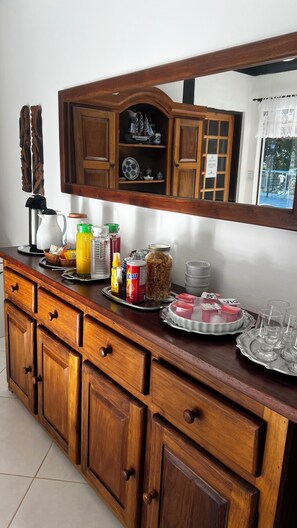 A wooden buffet counter with various food items and condiments. - Pousada Vitória Régia - Hotel Costeira (São Sebastião)