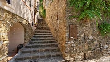 A narrow stone staircase leading up to a building with a wooden sign.