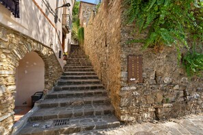 A narrow stone staircase leading up to a building with a wooden sign. - Giardino Siniscalchi – Apartment 1 with Wi-Fi and Air Conditioning (Copersito)