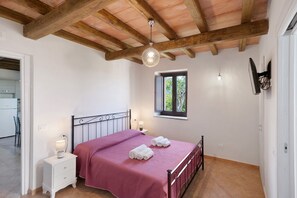 A bedroom with a bed, bedside tables, a window, and a ceiling fan. - Giardino Siniscalchi – Apartment 1 with Wi-Fi and Air Conditioning (Copersito)