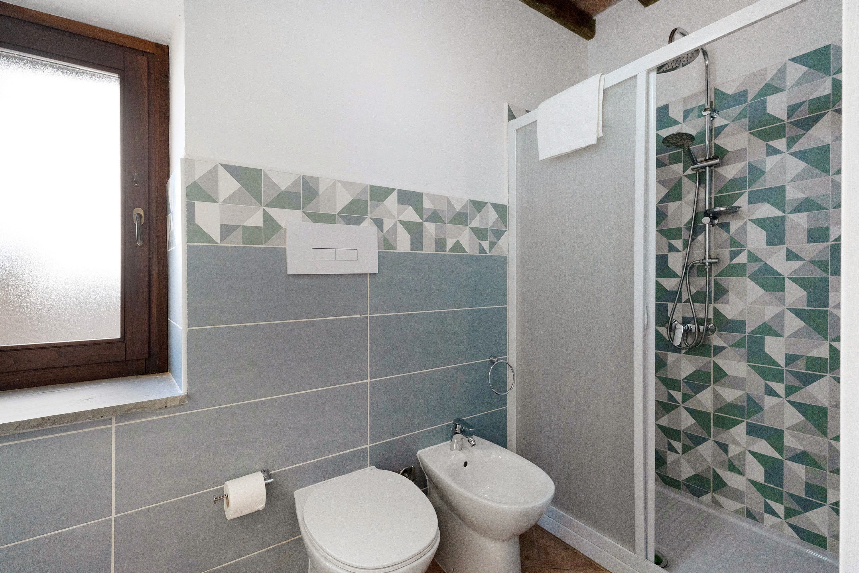 Ein Badezimmer mit Toilette, Bidet und Dusche.