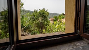 A window with a view of a mountainous landscape and traditional architecture. - Giardino Siniscalchi – Apartment 1 with Wi-Fi and Air Conditioning (Copersito)