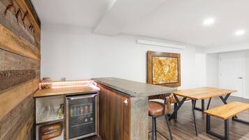 Eine kompakte Küche mit integriertem Kühlschrank, einer Holztresore und einer Sitzecke mit Bank und Barhockern.