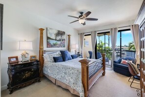 A bedroom with a four-poster bed, a ceiling fan, a balcony with a view, and a painting on the wall. - Beautiful Marina views (Cape Coral)