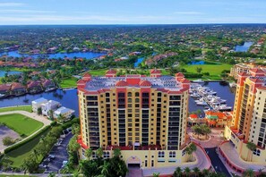 A high-rise hotel with multiple balconies, a marina, and a view of a residential area. - Townhouse in Cape Harbour- Sleeps 8 (Cape Coral)
