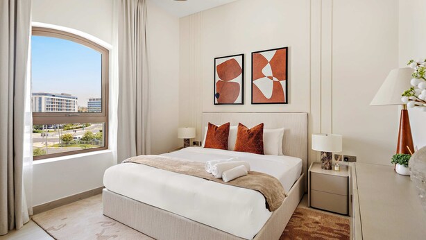 A hotel room with a large bed, two nightstands, a window with curtains, and abstract wall art. - Silkhaus Premium 1BR Stay in Yas Golf Collection (Abu Dhabi)