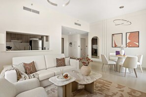 A modern living room with a sofa, coffee table, and decorative vase. - Silkhaus Premium 1BR Stay in Yas Golf Collection (Abu Dhabi)