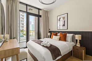 A hotel room with a bed, bedside table, lamp, and a view of buildings through the window. - Silkhaus Canal Walk 1BR Stay in Al Maryah Island (Abu Dhabi)