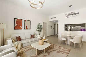 Ein modernes Wohnzimmer mit Sofa, Couchtisch und Kunstwerken. Es gibt einen Essbereich mit Tisch und Stühlen.