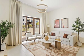 A modern living room with a sofa, chairs, a coffee table, and a large window with a view of a building.