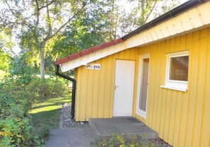 A yellow building with a door and a window, labeled with the number 213. - Gemutlich Eingerichteter Doppelbungalow mit Garten in Mirow (Mirow)