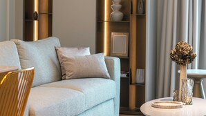 A modern living room with a sofa, a round coffee table, and a tall shelving unit with decorative items. - Pearl: Luxury and Design in the Heart of Viale Ceccarini (Riccione)