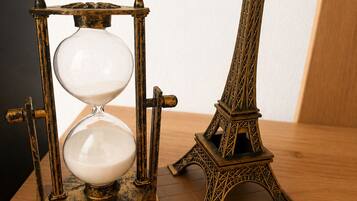 A brass hourglass and a miniature Eiffel Tower on a wooden base.