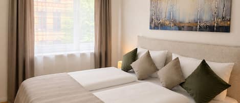 A double bed with a striped bedspread, a headboard, and multiple pillows.