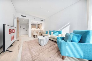 Una sala de estar moderna con un sofá, una mesa de centro y un mueble para televisión.
