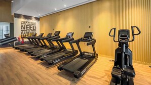 A gym with multiple treadmills lined up against a wall with a motivational quote. - StayShort - Prime 1 Bedroom Sleeps 2 in Palm Jumeirah (Dubai)