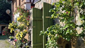 Un sendero adoquinado que conduce a un edificio tradicional con pared de piedra y puerta de madera.