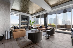 Ein modernes Wohnzimmer mit großem Fenster, einer Couch, einem Couchtisch und einer Pflanze.