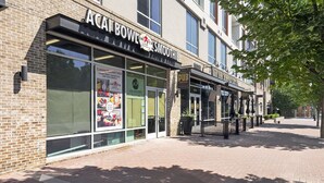 Un escaparate con un cartel que dice 'ACAI BOWL SMOOTHIE' y 'THE PUB', con fachada de ladrillo y ventanas amplias.