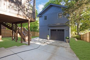 Ein Wohnhaus mit überdachter Terrasse, Garage und gepflegtem Rasen.