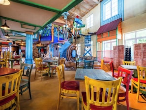A restaurant with wooden tables and chairs, a colorful interior, and a rustic decor.